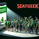 a stylized illustration. It shows a massive smartphone on its side with the screen facing forward. The screen reads "TICKETS" in bold white letters on a green background, and the brand name "SEATGEEK" is in large red letters at the top against a black background. A 3D effect makes it appear as if a group of people is standing in line, waiting to approach the phone screen.